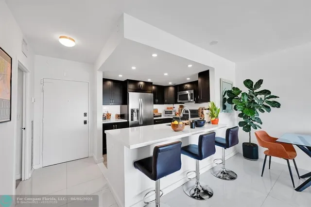 a living room with furniture kitchen view and a flat screen tv