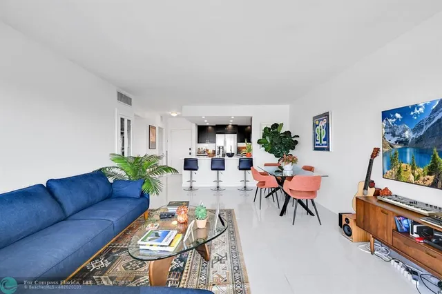 a living room with furniture a flat screen tv and a dining table