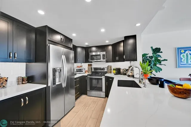 a kitchen with sink refrigerator and stove