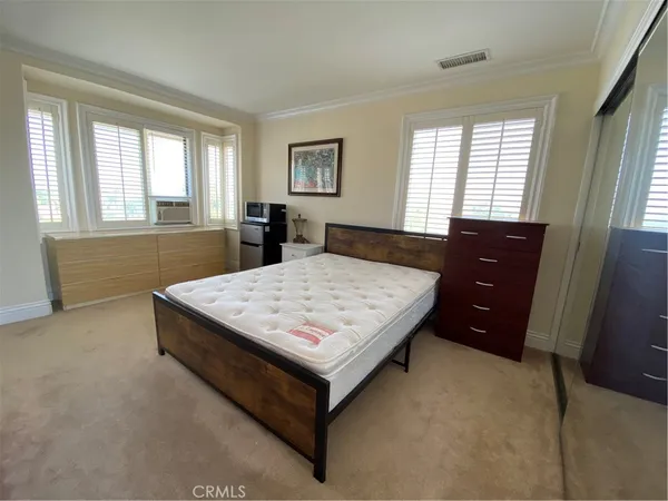 a bed sitting in a bedroom next to a window