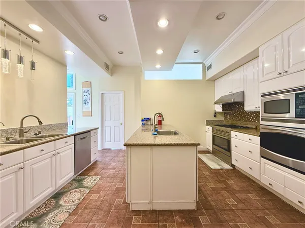 a kitchen with stainless steel appliances kitchen island granite countertop a sink and cabinets