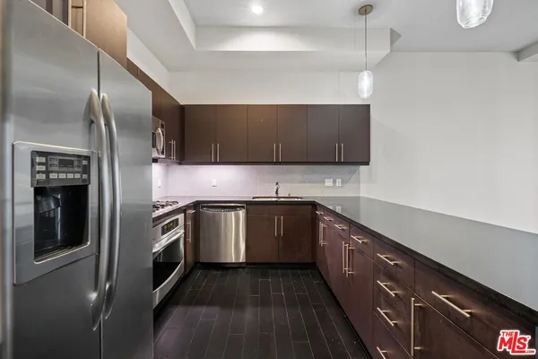 a kitchen with stainless steel appliances granite countertop a sink a stove and a refrigerator