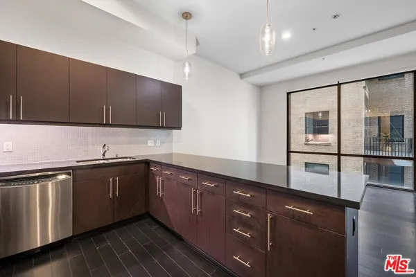 a kitchen with stainless steel appliances granite countertop wooden cabinets a sink and dishwasher