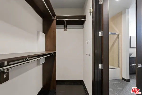 a view of walk in closet with clothes and shoes