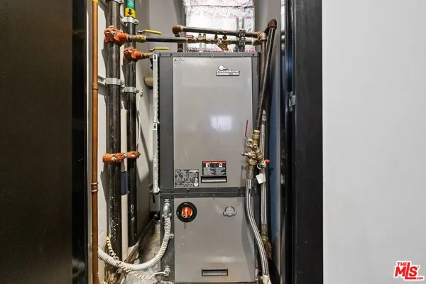 walk in closet with window and refrigerator