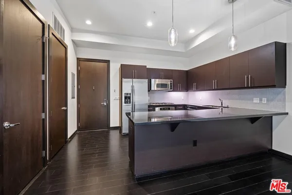 a kitchen with stainless steel appliances granite countertop a sink a stove and a refrigerator