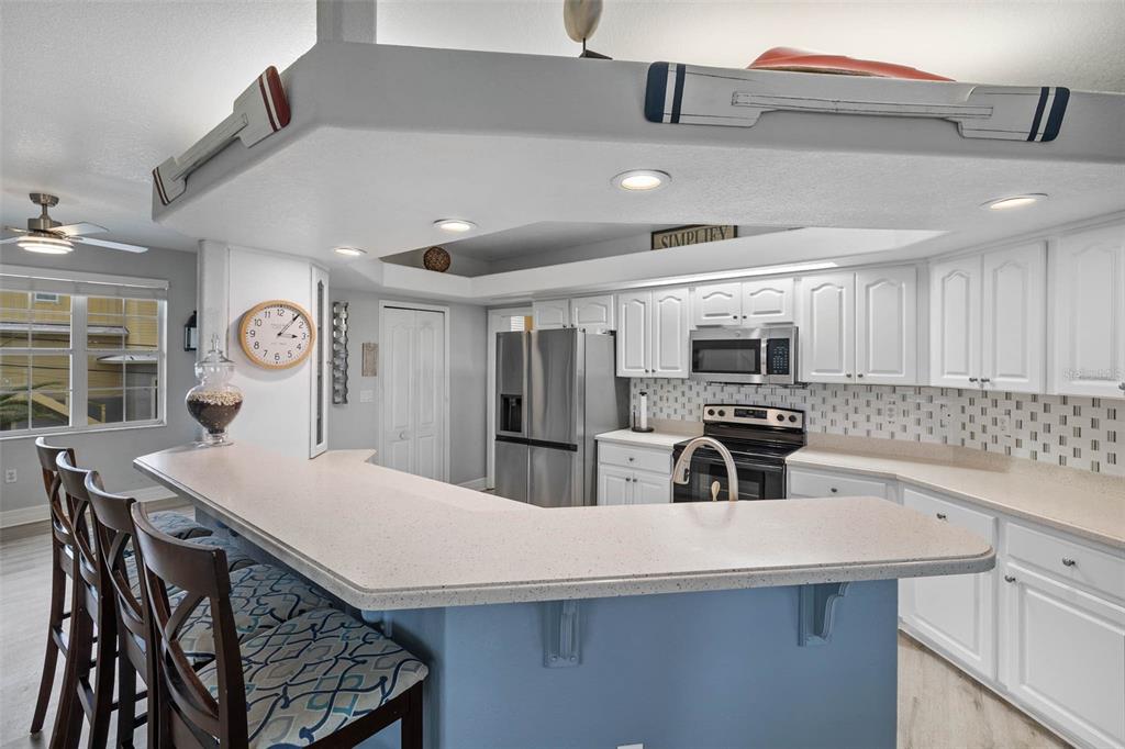 3280 Gulf Winds Circle Hernando Beach, FL 34607 - Photo 15 of 68 a kitchen with stainless steel appliances a table chairs and a refrigerator