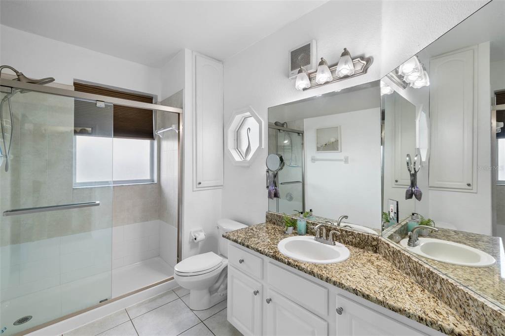 3280 Gulf Winds Circle Hernando Beach, FL 34607 - Photo 28 of 68 a bathroom with a granite countertop sink a toilet a mirror and shower