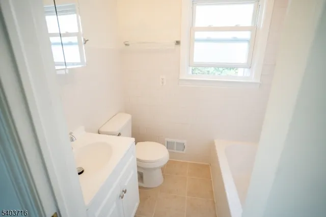 a white toilet sitting next to a bathroom sink
