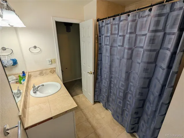 a bathroom with a sink a toilet and shower curtain