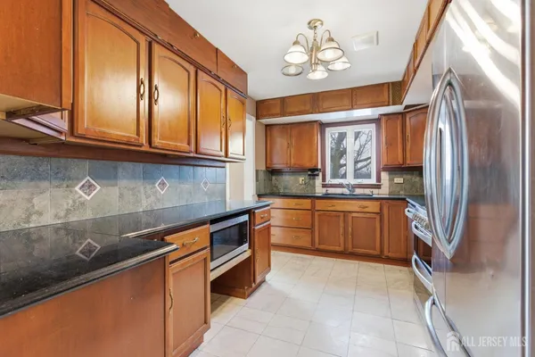 a kitchen with stainless steel appliances granite countertop a refrigerator and a sink