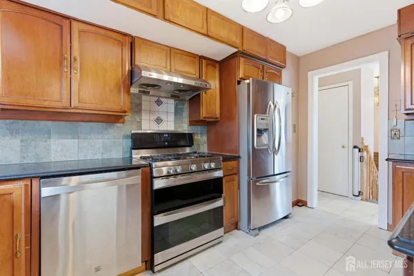 a kitchen with stainless steel appliances granite countertop a refrigerator and a stove