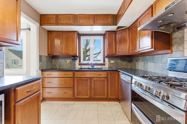 a kitchen with stainless steel appliances granite countertop a stove and a sink