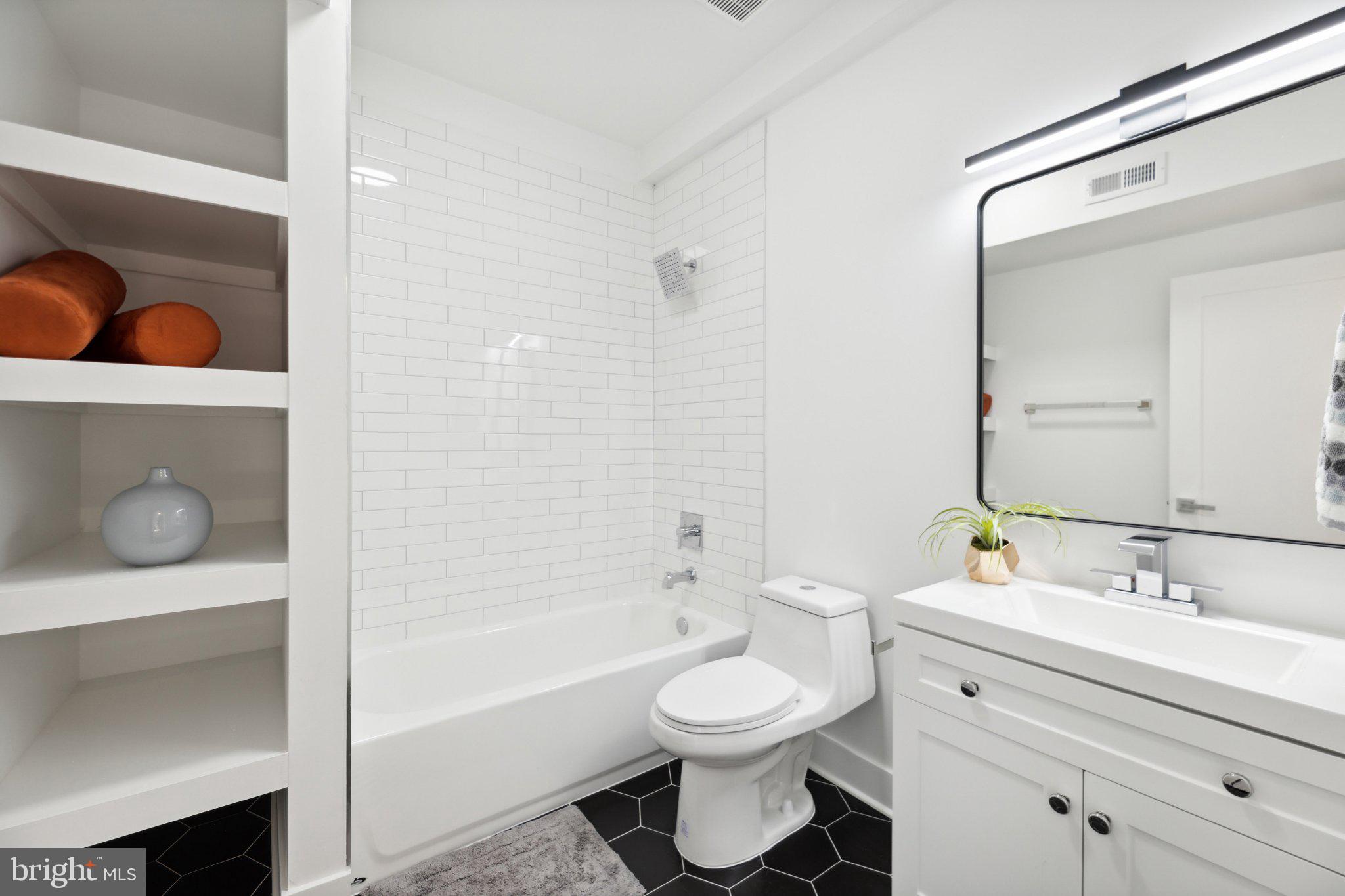 1621 T Street Southeast, Unit 8 Washington, DC 20020 - Photo 6 of 8 a bathroom with a toilet a sink a tub and mirror