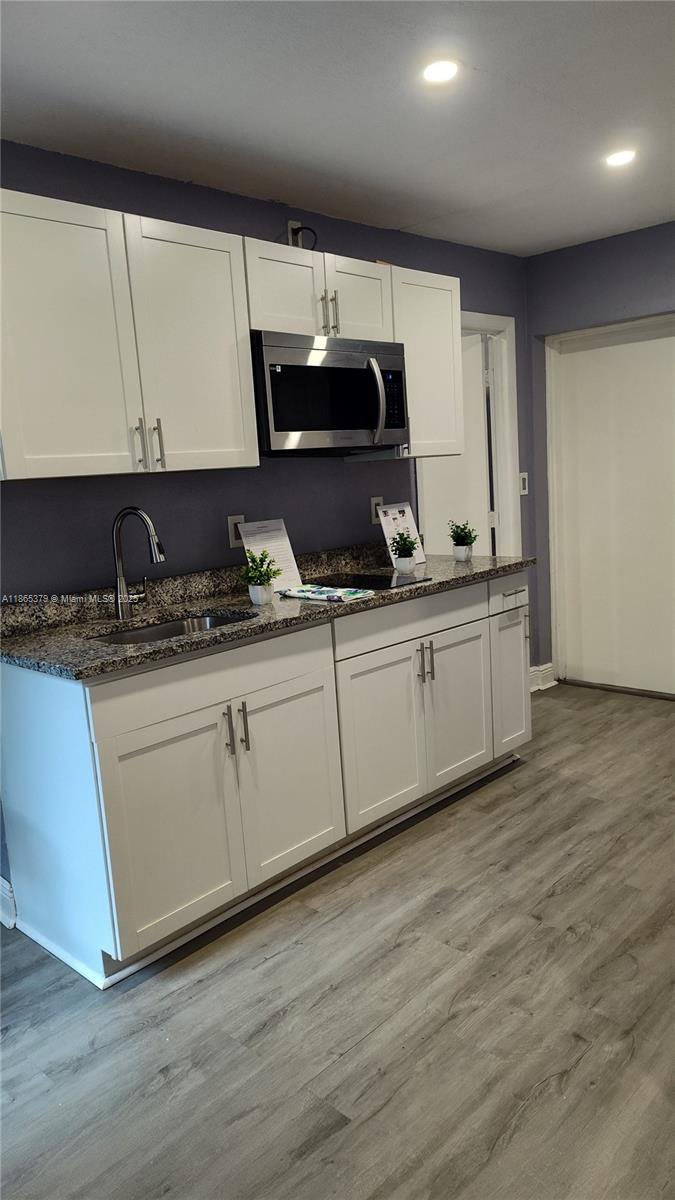 849 West 2nd Street, Unit B Riviera Beach, FL 33404 - Photo 2 of 10 a kitchen with stainless steel appliances granite countertop a sink a stove and cabinets