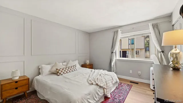 a bedroom with a bed and a lamp on the dresser