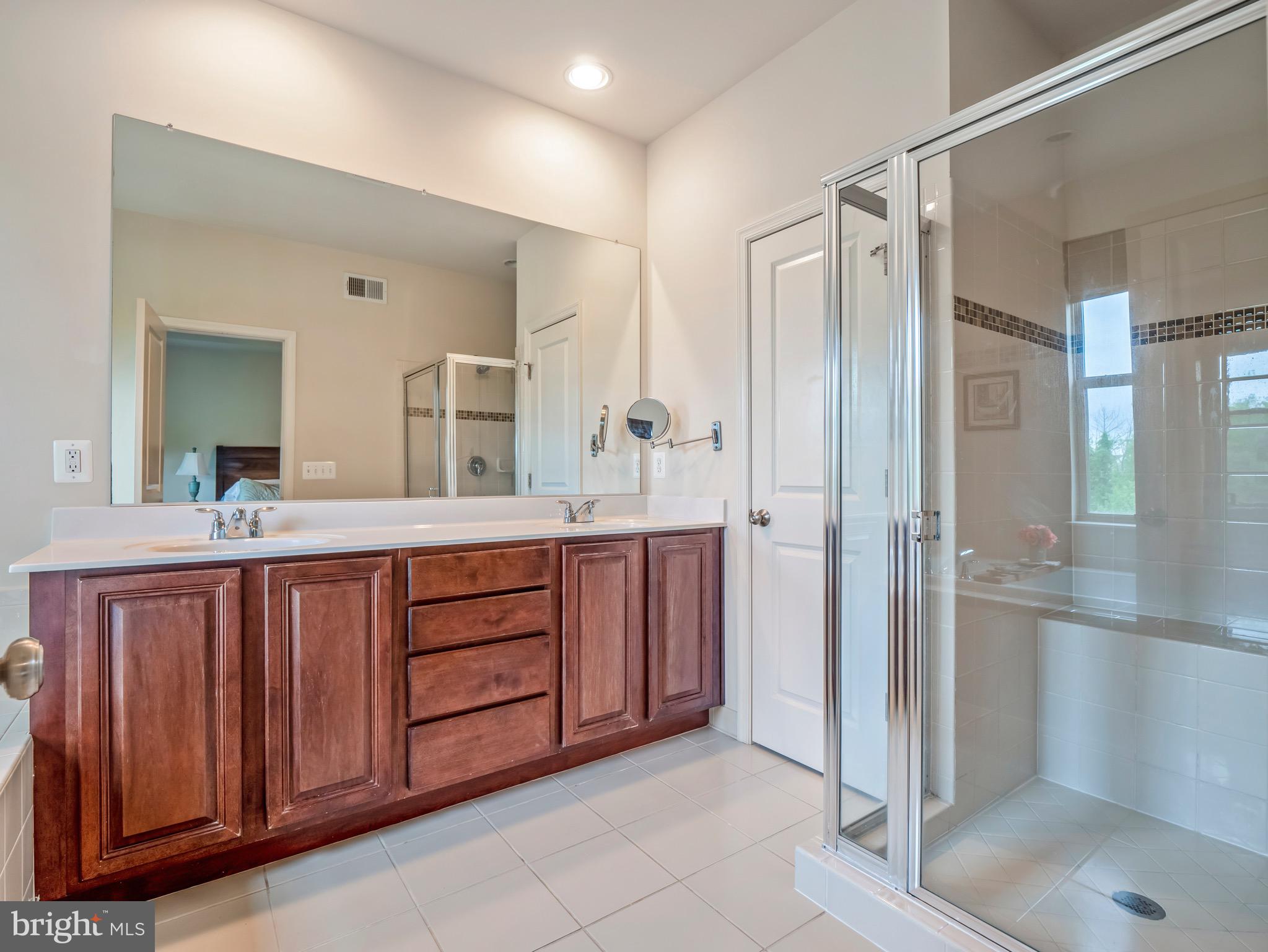 23366 Evening Primrose Square Brambleton, VA 20148 - Photo 17 of 28 a bathroom with a double vanity sink and a mirror