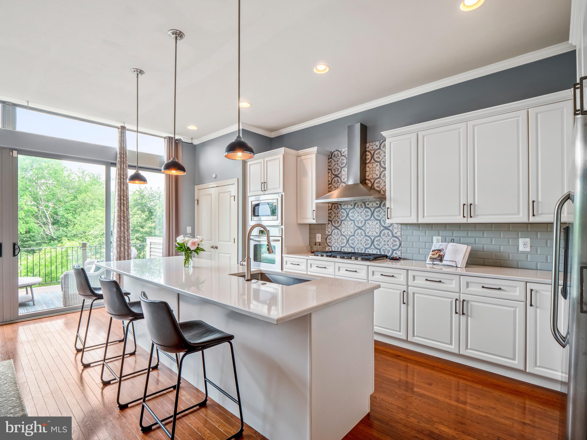 23366 Evening Primrose Square Brambleton, VA 20148 - Photo 7 of 28 a kitchen with stainless steel appliances granite countertop a stove a sink dishwasher and white cabinets with wooden floor