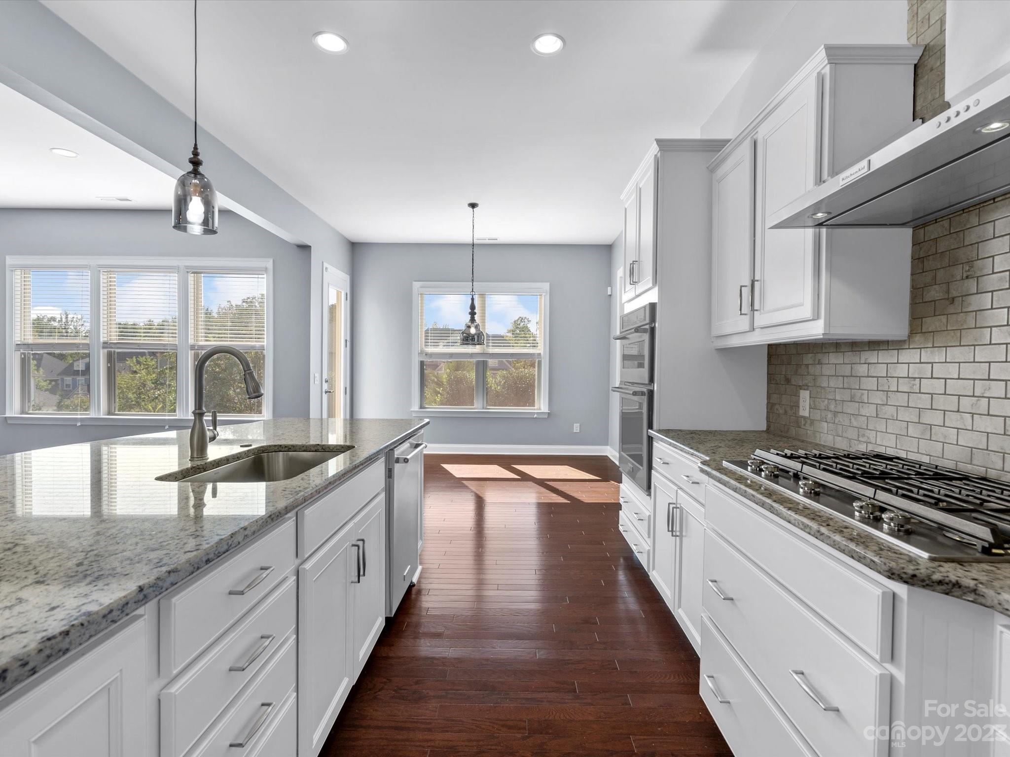 7009 Fallondale Road Waxhaw, NC 28173 - Photo 23 of 47 a large kitchen with granite countertop a large stove a sink and white cabinets