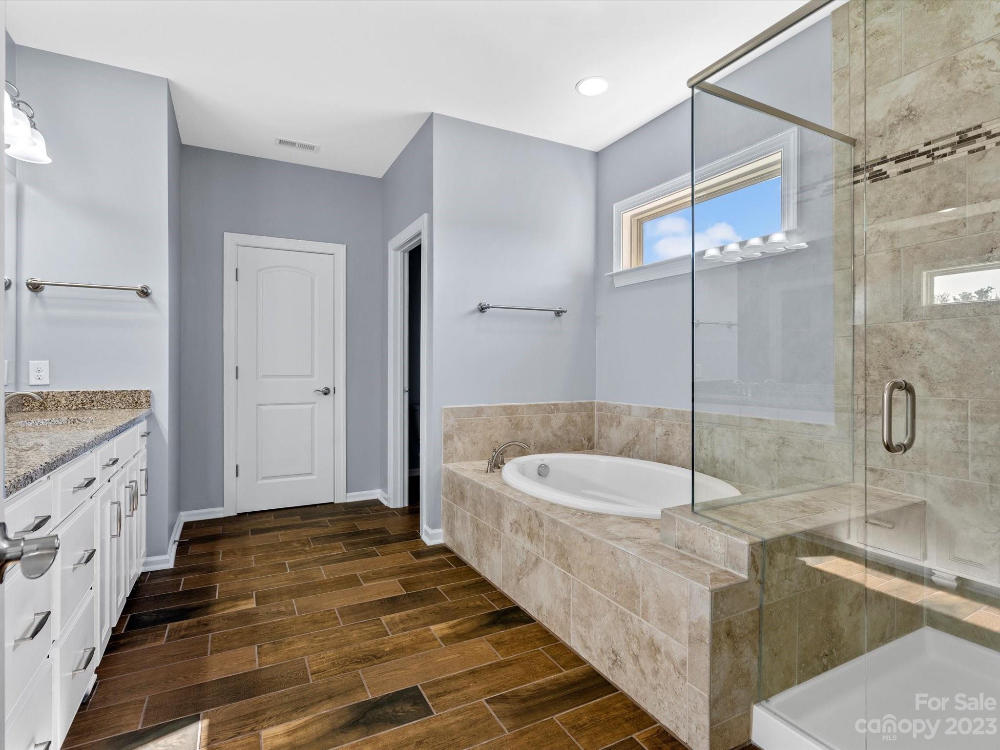 7009 Fallondale Road Waxhaw, NC 28173 - Photo 36 of 47 a spacious bathroom with a granite countertop tub sink a shower and a mirror