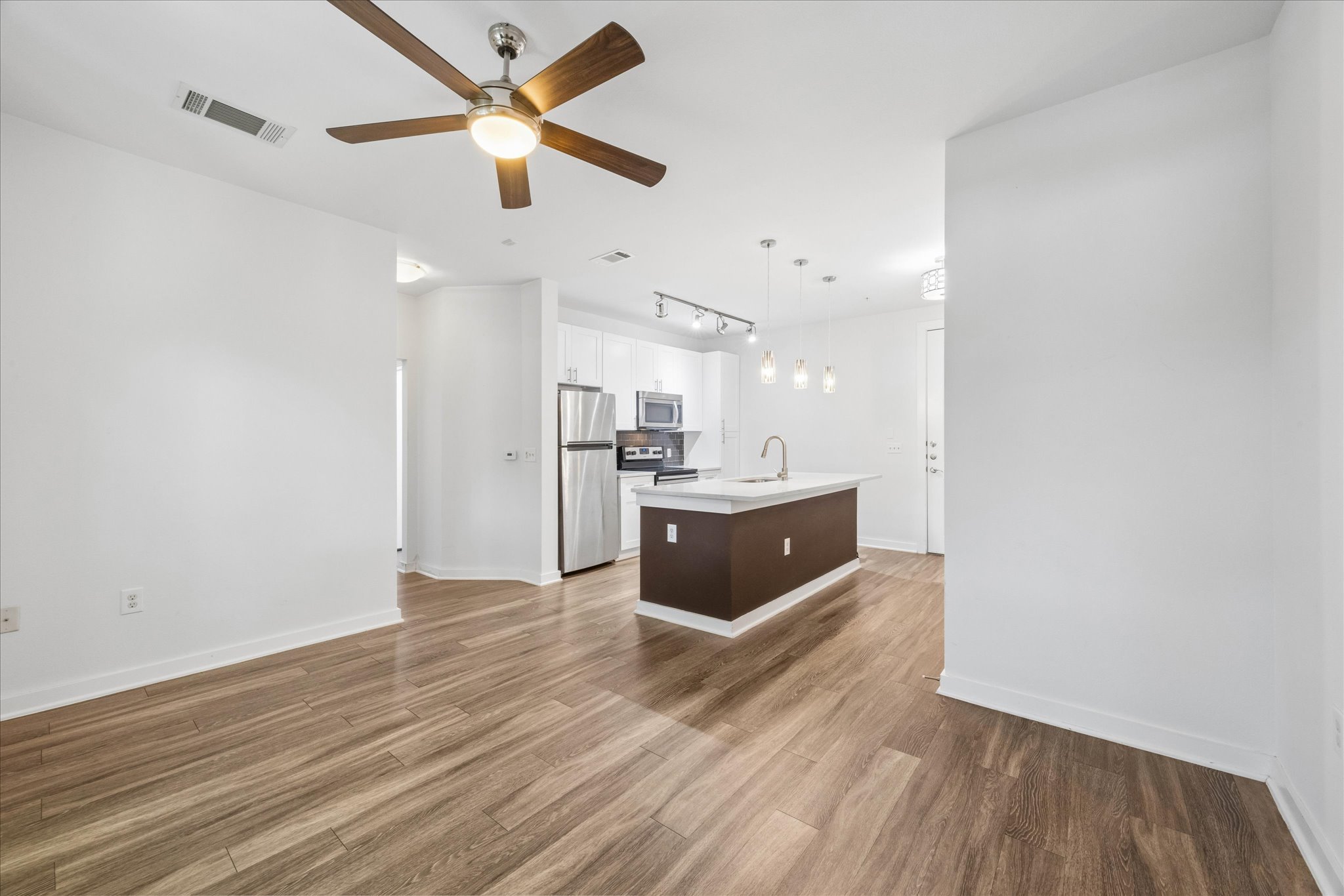 1900 Barton Springs Road, Unit 4041 Austin, TX 78704 - Photo 17 of 35 An open-concept living space with a contemporary kitchen island and sleek wood flooring.