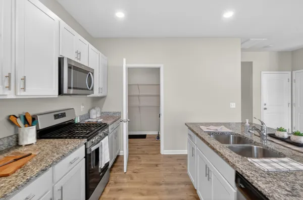 a kitchen with granite countertop sink and refrigerator