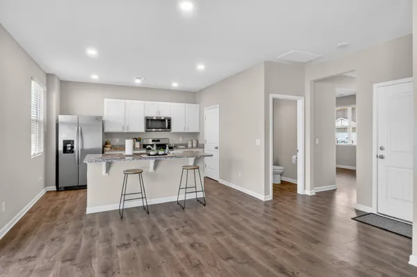 a kitchen with stainless steel appliances a refrigerator a stove top oven and a center island