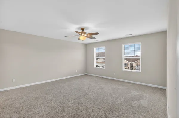 a spacious bedroom with a bed a couch and a flat screen tv