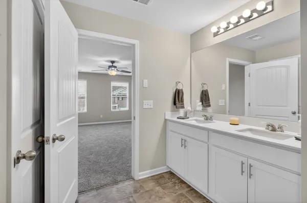 a spacious bathroom with a double vanity sink a mirror and a
