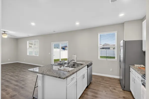 a view of open kitchen with wooden floor and chandelier