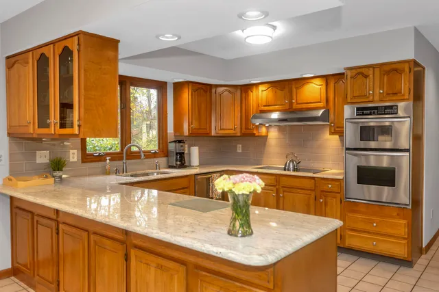 a kitchen with stainless steel appliances granite countertop a sink and a refrigerator