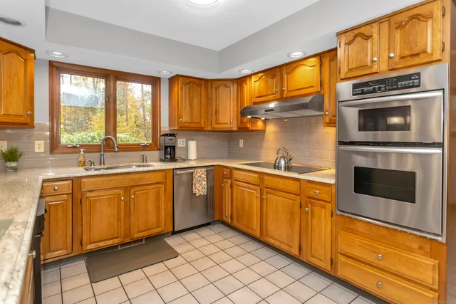 a kitchen with stainless steel appliances granite countertop a stove sink and microwave
