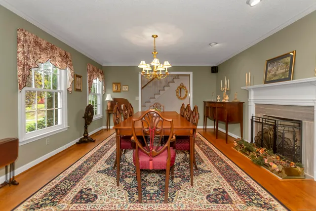 a view of a dining room with furniture a chandelier and wooden floor