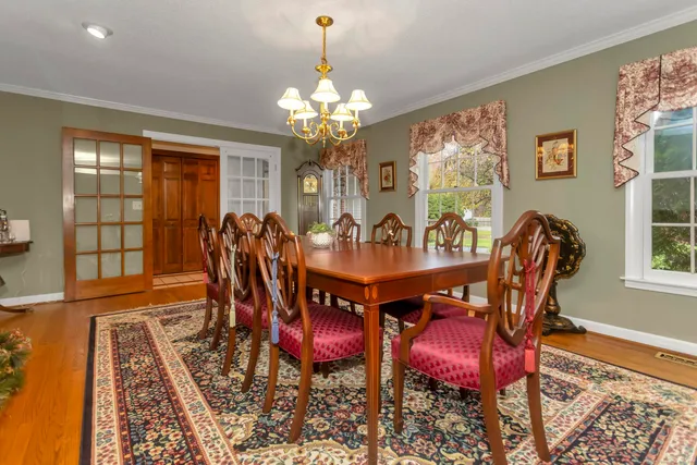 a view of a dining room with furniture a chandelier and wooden floor