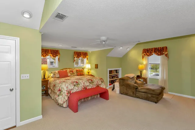 a spacious bedroom with a bed and ceiling fan