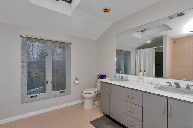 a spacious bathroom with a double vanity sink mirror and toilet