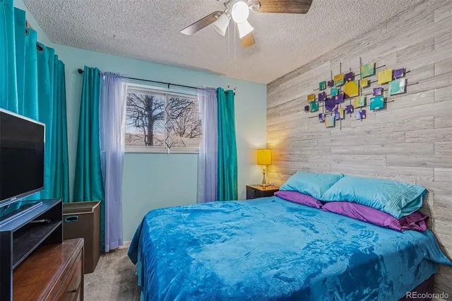 a bedroom with a bed and a flat tv screen on dresser