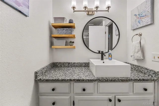 a bathroom with a granite countertop sink and a mirror