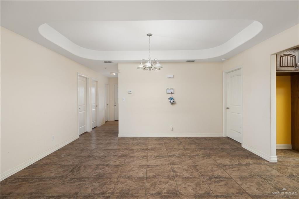 417 Jessica Street Mercedes, TX 78570 - Photo 4 of 12 an empty room with a chandelier fan and windows