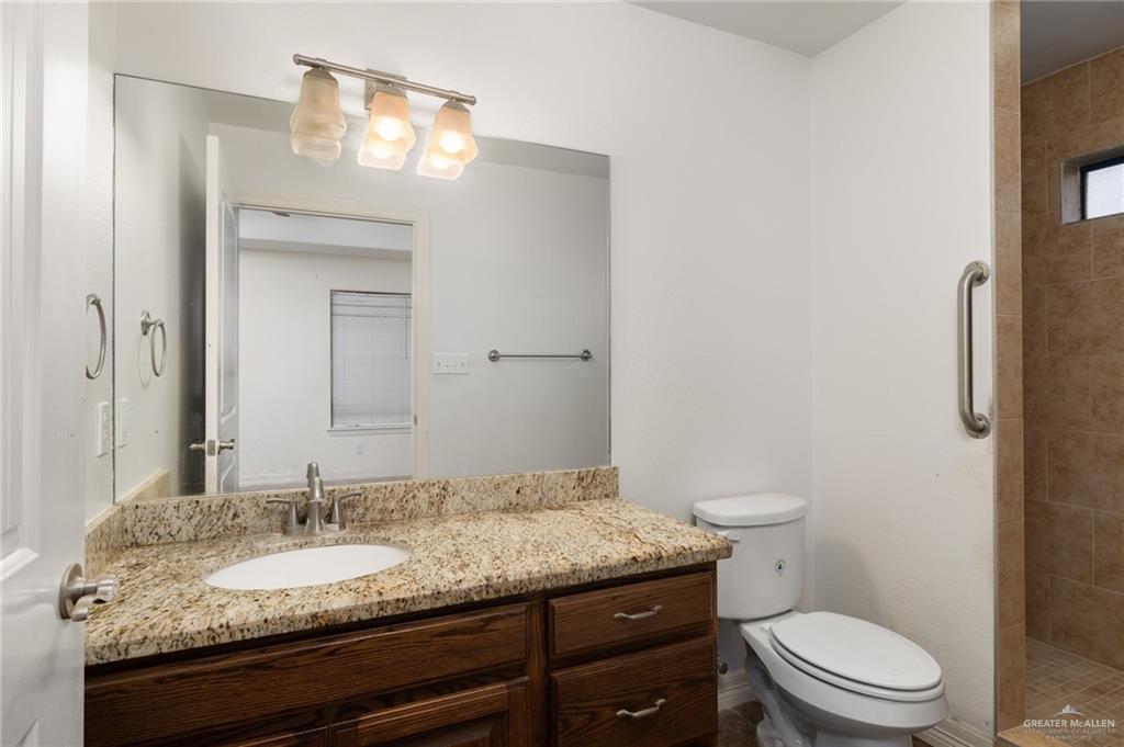 417 Jessica Street Mercedes, TX 78570 - Photo 7 of 12 a bathroom with a granite countertop sink toilet and mirror