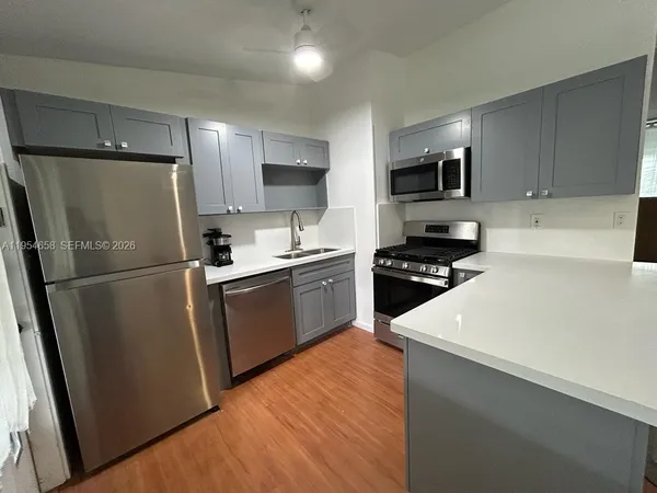 a kitchen with stainless steel appliances a refrigerator stove microwave and sink