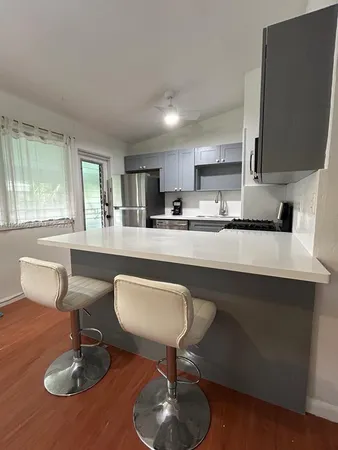 a kitchen with granite countertop a table chairs stove a sink dishwasher and cabinets