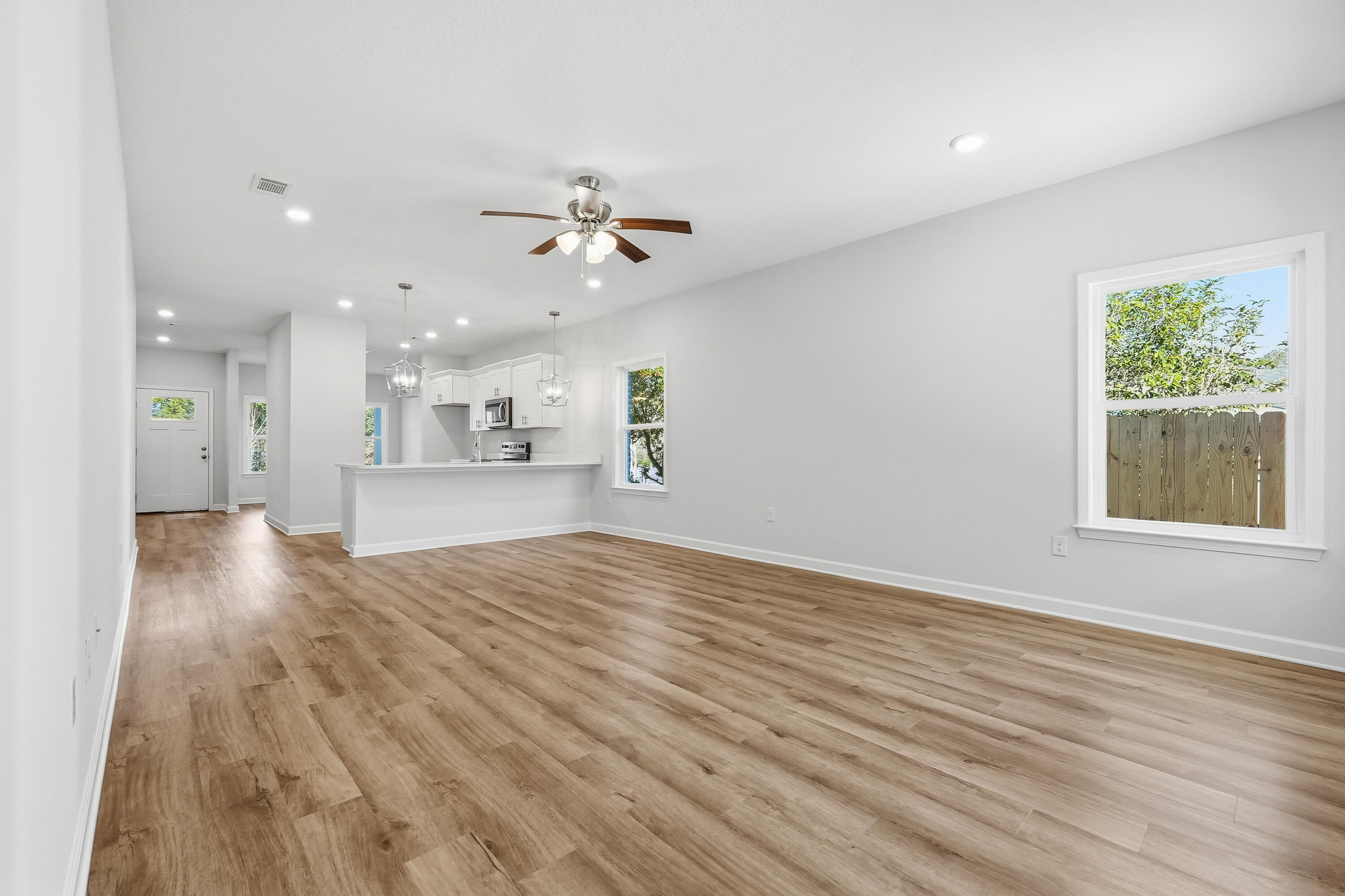 71 Spooner Street DeFuniak Springs, FL 32433 - Photo 12 of 22 a view of an empty room with a window and wooden floor