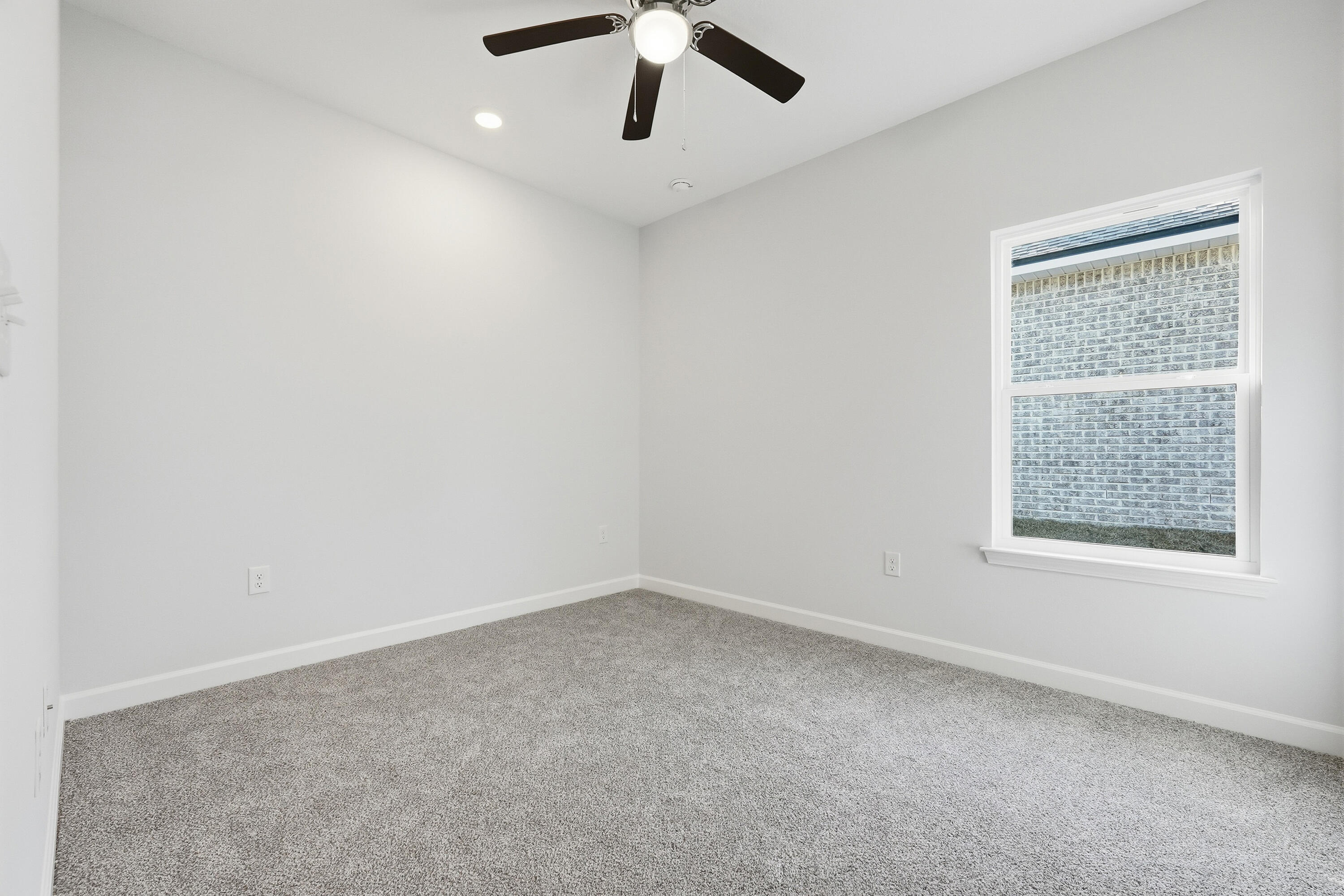 71 Spooner Street DeFuniak Springs, FL 32433 - Photo 17 of 22 an empty room with a window and a fan