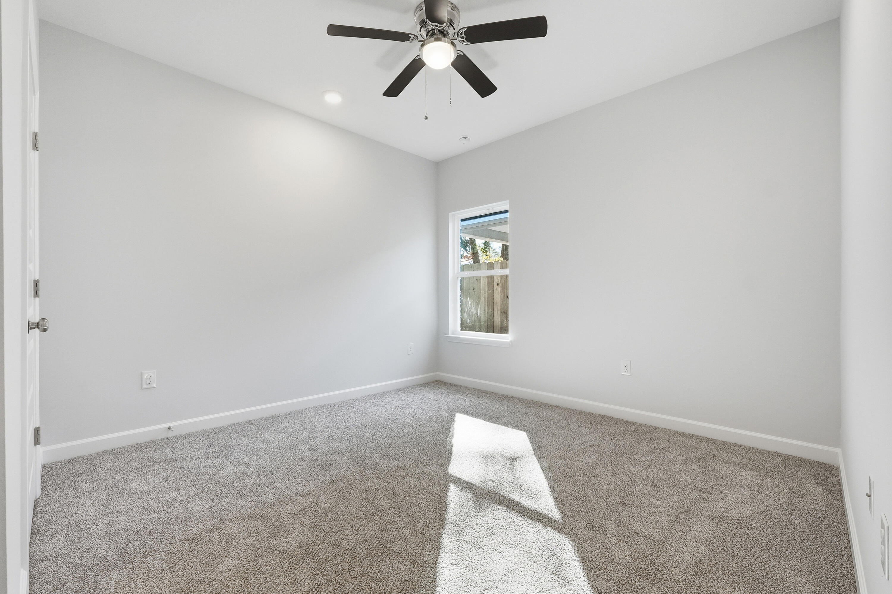 71 Spooner Street DeFuniak Springs, FL 32433 - Photo 18 of 22 an empty room with windows and fan