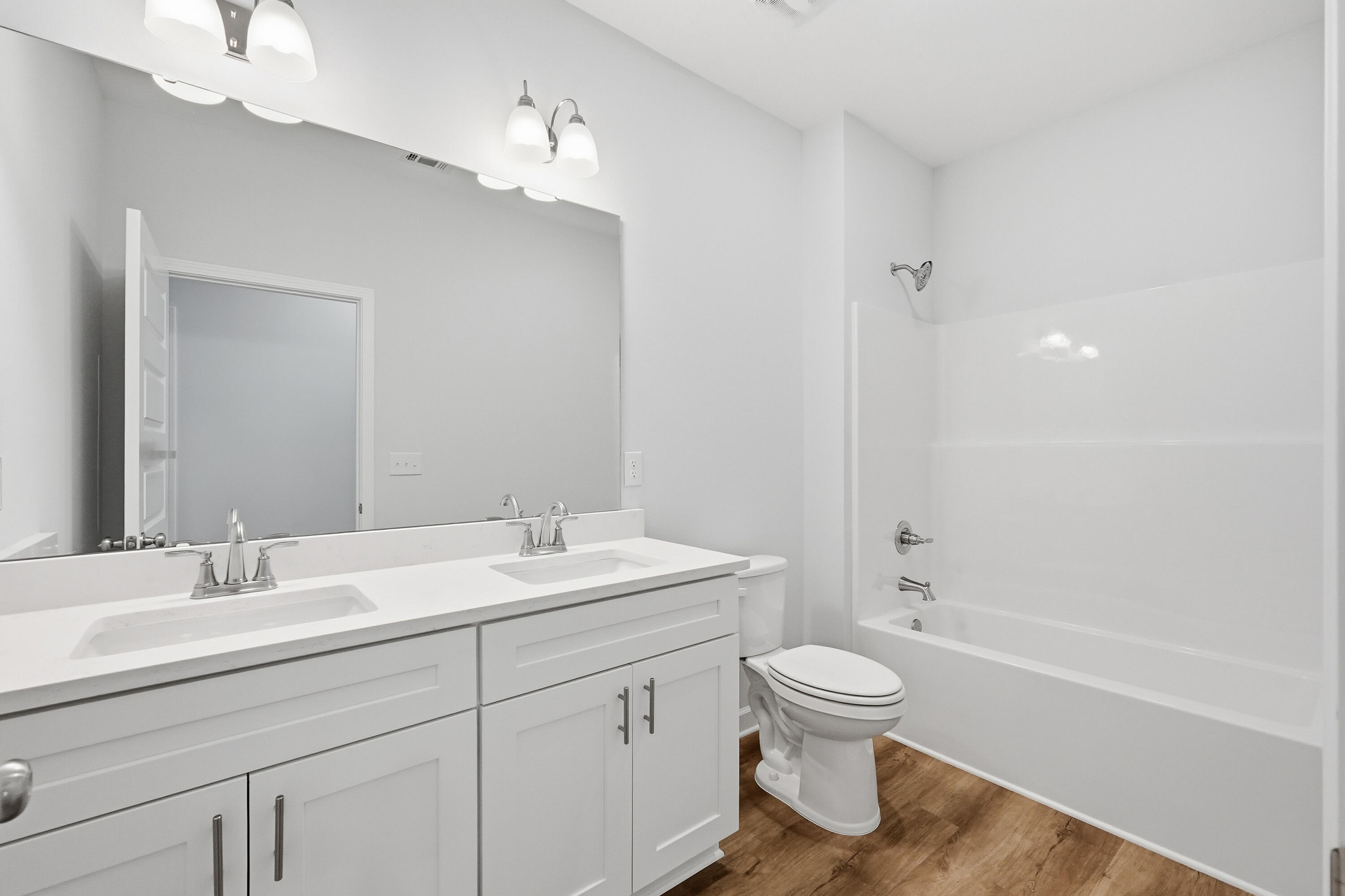 71 Spooner Street DeFuniak Springs, FL 32433 - Photo 19 of 22 a bathroom with a toilet a sink a mirror and a bathtub