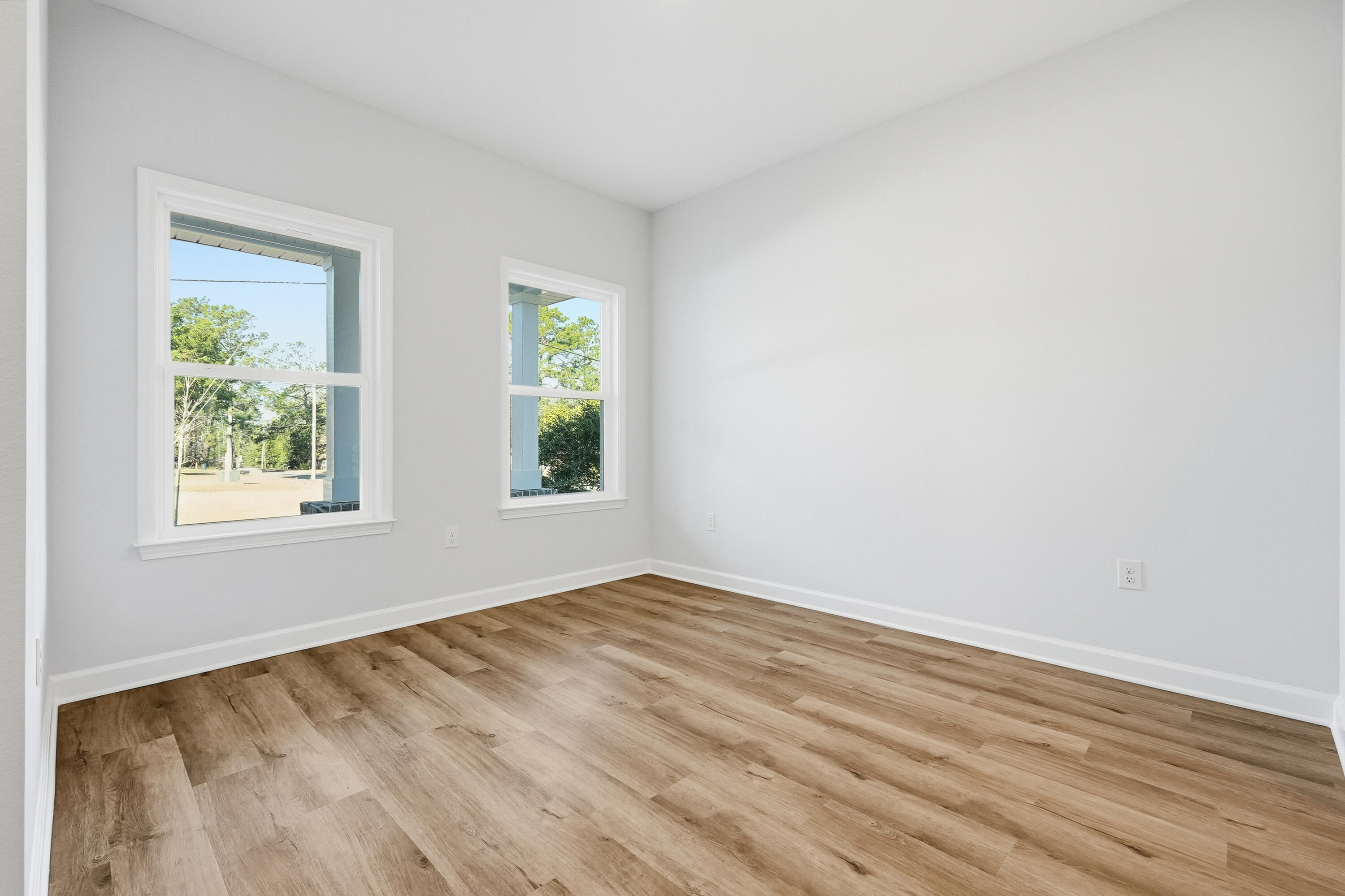 71 Spooner Street DeFuniak Springs, FL 32433 - Photo 4 of 22 an empty room with wooden floor and windows