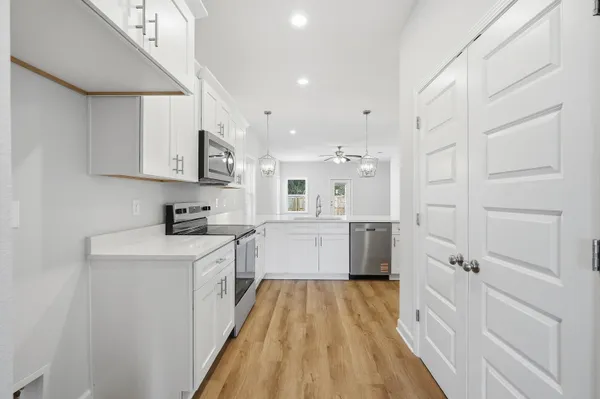 a kitchen with cabinets and wooden floor
