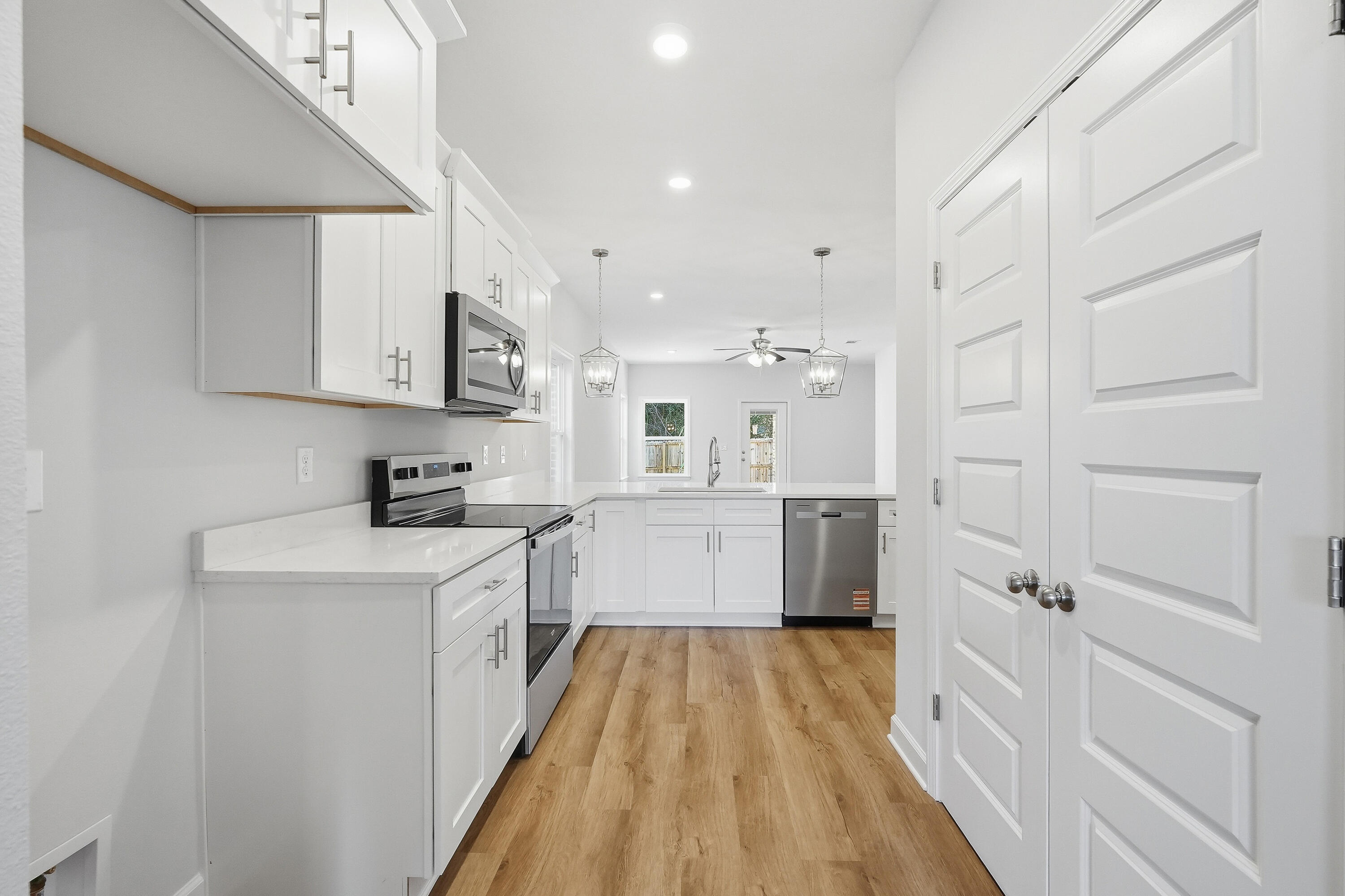 71 Spooner Street DeFuniak Springs, FL 32433 - Photo 5 of 22 a kitchen with cabinets and wooden floor