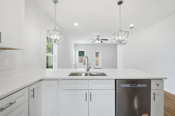 a view of a double sink and chandelier in a kitchen